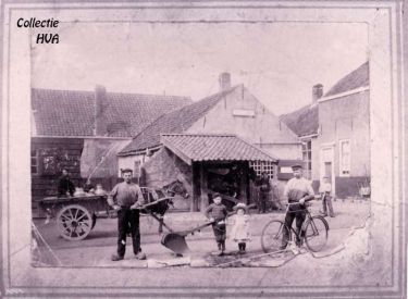 De oude smederij van de hoefsmid Van der Weele met ervoor de travalje voor het beslaan van de paarden en het gemeentelijk aanplakbord. De oude smederij van de hoefsmid Van der Weele met ervoor de travalje voor het beslaan van de paarden en het gemeentelijk aanplakbord.