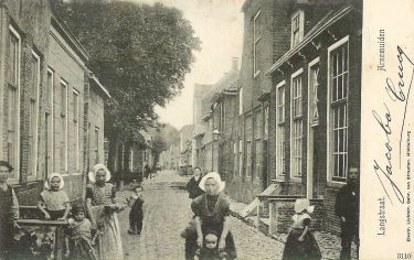 De Langstraat met links de Markt en aan het eind de openbare school. Op de hoek Langstraat/Marktstraat staat het oude huis met de timmermanswinkel van Daniël van Eenennaam. Op de plaats van het af te breken huis worden nieuwe woningen gebouwd. De Langstraat met links de Markt en aan het eind de openbare school. Op de hoek Langstraat/Marktstraat staat het oude huis met de timmermanswinkel van Daniël van Eenennaam. Op de plaats van het af te breken huis worden nieuwe woningen gebouwd.
