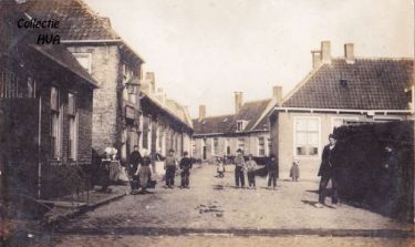 De vuilnisgoot is op de foto te zien. Links de smederij van J.L. Buijs. Daarnaast het café van weduwe Menheere. Op het bord is te lezen: ‘In het schippershuis alhier. Tapt men sterke dranken, wijn en bier’. Rechts op de hoek de bakkerij van S. van Eenennaam. De vuilnisgoot is op de foto te zien. Links de smederij van J.L. Buijs. Daarnaast het café van weduwe Menheere. Op het bord is te lezen: ‘In het schippershuis alhier. Tapt men sterke dranken, wijn en bier’. Rechts op de hoek de bakkerij van S. van Eenennaam.