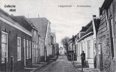 In 1915 verstuurt een in Arnemuiden gelegerde militair deze kaart van de Langstraat. Links is de door ds. Runia bewoonde oude pastorie (met lantaarn) en rechts de wagenmakerij van Dingenis Kousemaker te zien. In 1915 verstuurt een in Arnemuiden gelegerde militair deze kaart van de Langstraat. Links is de door ds. Runia bewoonde oude pastorie (met lantaarn) en rechts de wagenmakerij van Dingenis Kousemaker te zien.