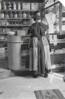 In de bakkerswinkel van A. Adriaanse op de Markt. Achter de toonbank M. Adriaanse-Joosse en ervoor de weduwe Tan Ventevogel. In de bakkerswinkel van A. Adriaanse op de Markt. Achter de toonbank M. Adriaanse-Joosse en ervoor de weduwe Tan Ventevogel.