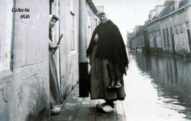 G. Schroevers en in de deuropening K. Theune kijken somber de Nieuwstraat in. Het water komt hier nog net niet boven het trottoir. G. Schroevers en in de deuropening K. Theune kijken somber de Nieuwstraat in. Het water komt hier nog net niet boven het trottoir.