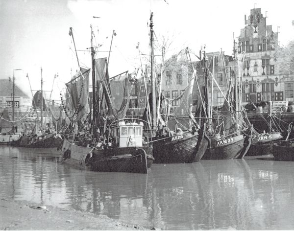 Wat een bonte bedrijvigheid in de vissershaven van Veere, voor de Schotse Huizen en links de vismijn. (Uit collectie Jhr. W.L. den Beer Poortugael). Wat een bonte bedrijvigheid in de vissershaven van Veere, voor de Schotse Huizen en links de vismijn. (Uit collectie Jhr. W.L. den Beer Poortugael).