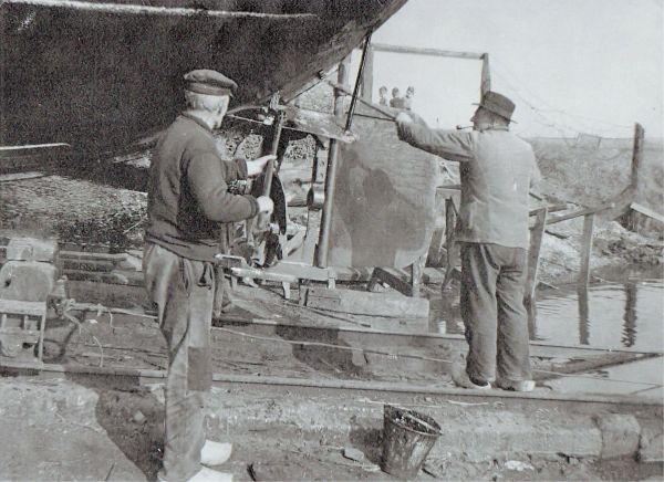 Op de werf is er altijd bedrijvigheid. Daar worden de vissersschepen opgekalefaterd of nieuwe hoogaarzen gebouwd. Hier wordt de romp geteerd. Vanaf het Schorretje kijkt de jeugd toe. (Uit collectie Jhr. W.L. den Beer Poortugael, Veere). Op de werf is er altijd bedrijvigheid. Daar worden de vissersschepen opgekalefaterd of nieuwe hoogaarzen gebouwd. Hier wordt de romp geteerd. Vanaf het Schorretje kijkt de jeugd toe. (Uit collectie Jhr. W.L. den Beer Poortugael, Veere).