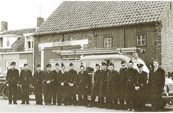 Het korps van de vrijwillige brandweer staat opgesteld voor de destijds verbouwde schuur aan het Schorretje tot brandweergarage ter gelegenheid van hun nieuwe uniformen. Naast burgemeester A. Hack staat commandant C. Boone. V.l.n.r. B. Bliek, A. van Dalen, C.J. Moerland, P. Janse sr, W. Joosse, W. Meulmeester, C. Blaasse, P. Janse jr, K. Meerman, J. Knolle, M. Knuyt, P de Klerk en P. Meertse. Het korps van de vrijwillige brandweer staat opgesteld voor de destijds verbouwde schuur aan het Schorretje tot brandweergarage ter gelegenheid van hun nieuwe uniformen. Naast burgemeester A. Hack staat commandant C. Boone. V.l.n.r. B. Bliek, A. van Dalen, C.J. Moerland, P. Janse sr, W. Joosse, W. Meulmeester, C. Blaasse, P. Janse jr, K. Meerman, J. Knolle, M. Knuyt, P de Klerk en P. Meertse.