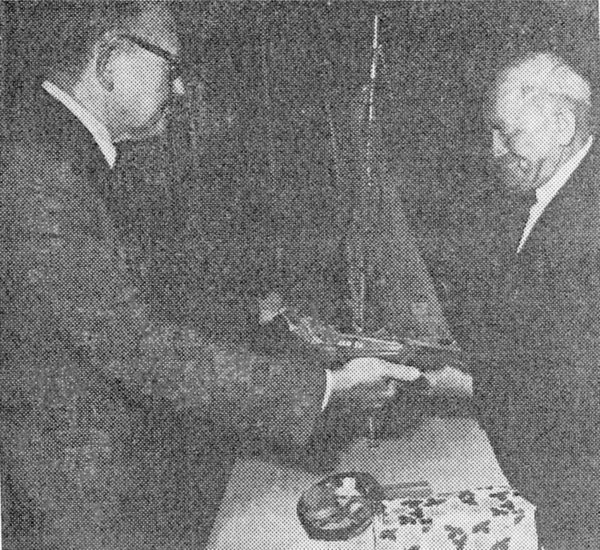 De nieuwe voorzitter van ZEVIBEL, de oud-burgemeester van Arnemuiden J. van den Bos, overhandigt de scheidende voorzitter van D.E.L. een modelhoogaars. De nieuwe voorzitter van ZEVIBEL, de oud-burgemeester van Arnemuiden J. van den Bos, overhandigt de scheidende voorzitter van D.E.L. een modelhoogaars.