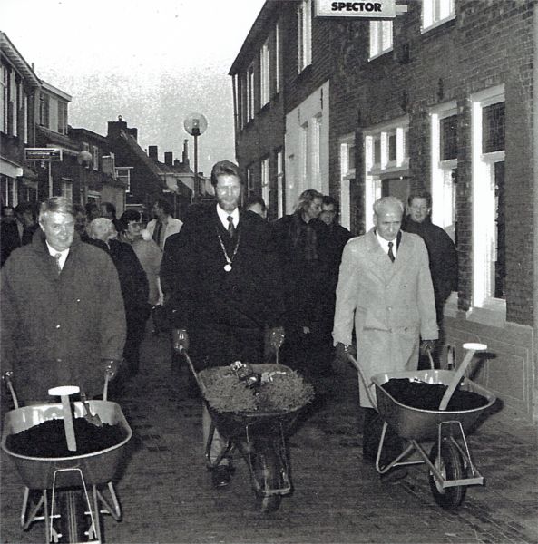 Met kruiwagens vol potaarde, viooltjes en coniferen voltooit het college van burgemeester en wethouders de verfraaiing van de vernieuwde Langstraat. V.l.n.r wethouder W. Bezemer, burgemeester H. Visser en wethouder J. van Belzen. Met kruiwagens vol potaarde, viooltjes en coniferen voltooit het college van burgemeester en wethouders de verfraaiing van de vernieuwde Langstraat. V.l.n.r wethouder W. Bezemer, burgemeester H. Visser en wethouder J. van Belzen.
