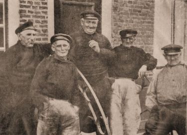 Oude vissers, rustend na een leven lang zwalken op zee in hun hoogaarzen. Links Joos van Belzen, de 88-jarige collectant voor de diaconie. Verder v.l.n.r nog een Joos van Belzen, Lieven van de Ketterij en Jozias de Rijke. Oude vissers, rustend na een leven lang zwalken op zee in hun hoogaarzen. Links Joos van Belzen, de 88-jarige collectant voor de diaconie. Verder v.l.n.r nog een Joos van Belzen, Lieven van de Ketterij en Jozias de Rijke.